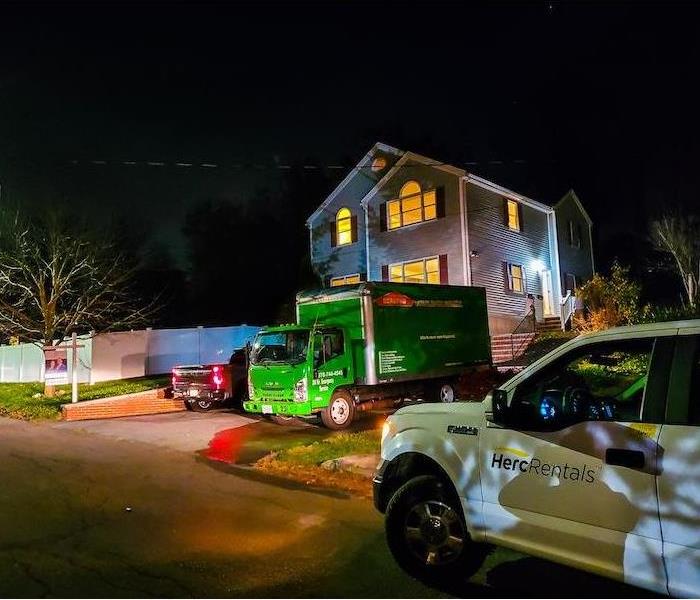 SERVPRO fleet vehicles in front of a home at night