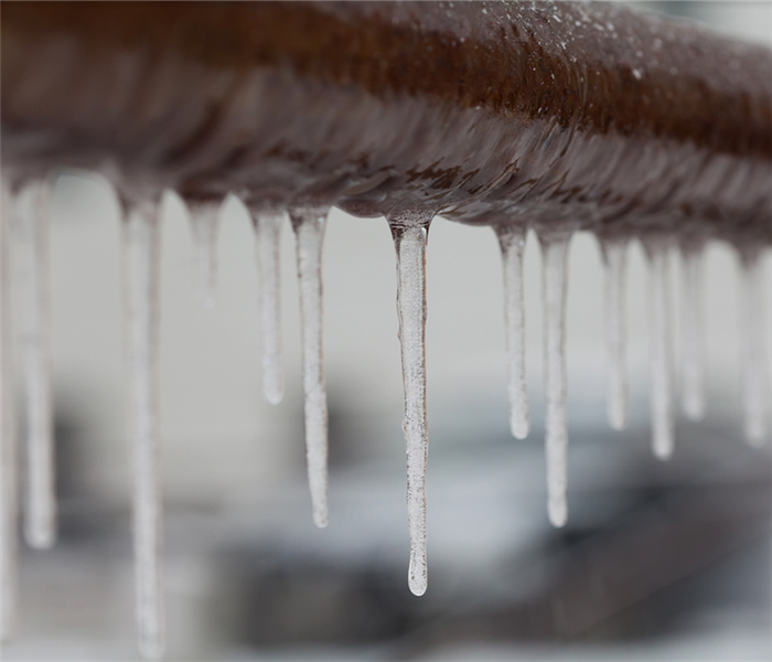 icicles hanging off of a frozen pipe