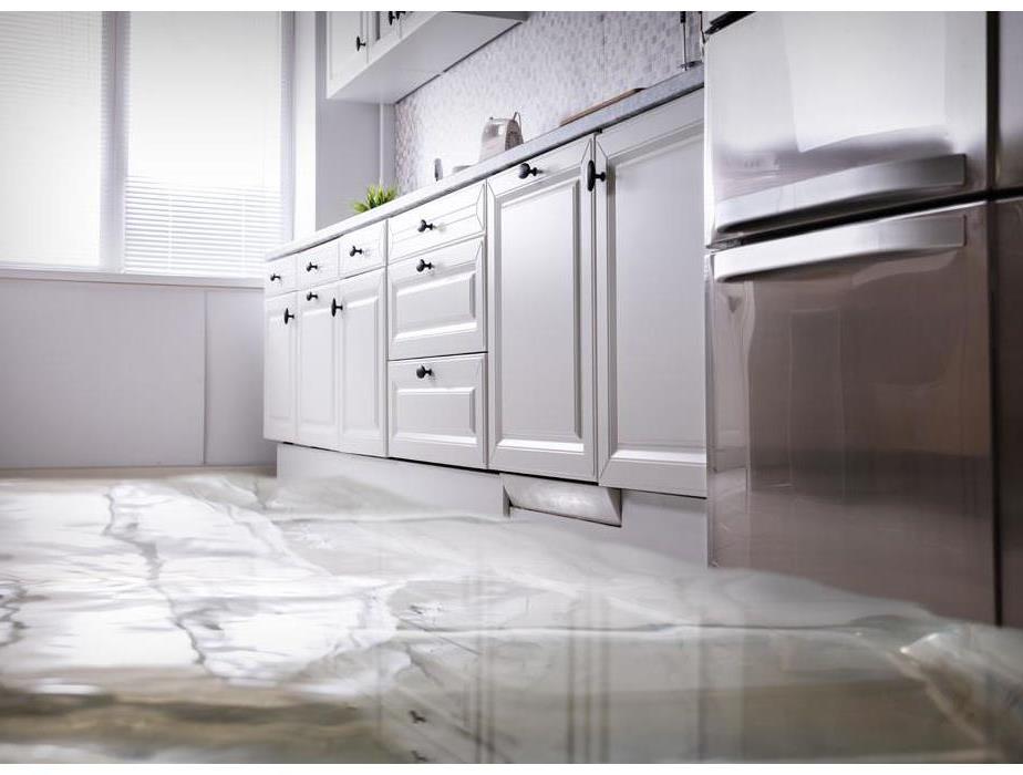 An apartment kitchen with water on the floor