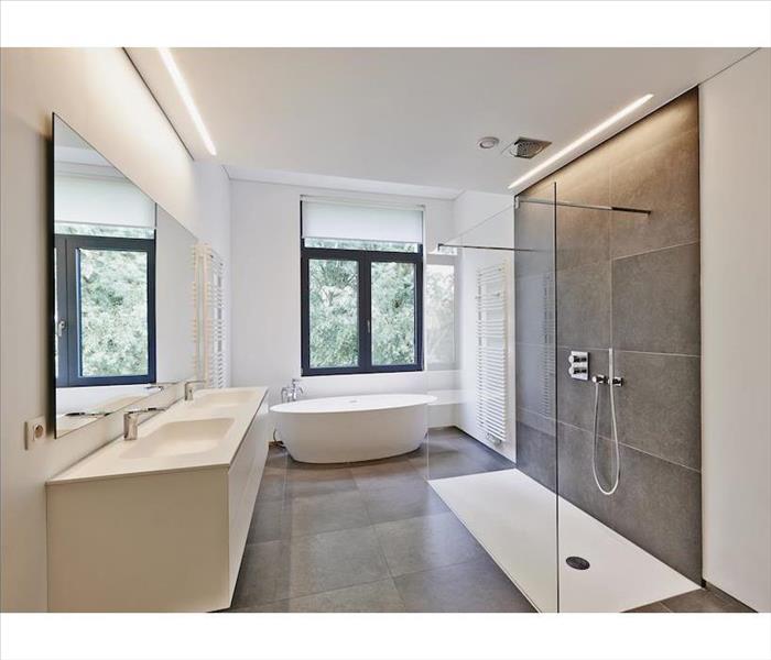 The same room converted into an attatractive luxury bath with free-standing tub and glass shower enclosure